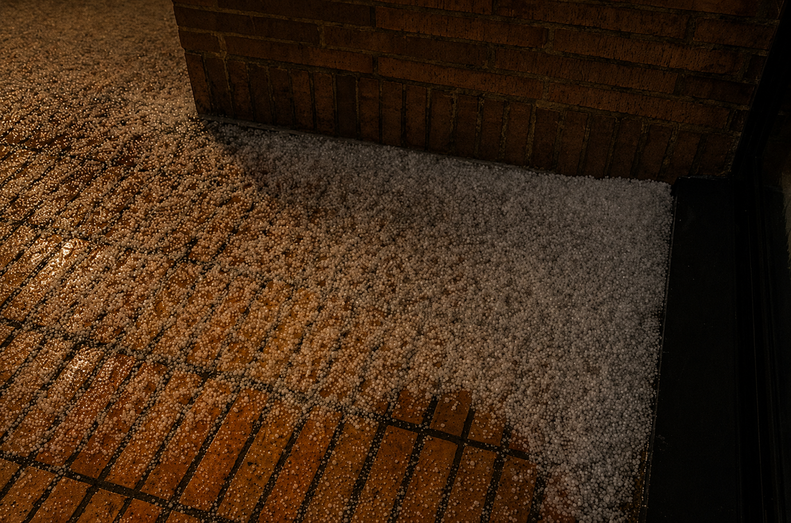 Granizo en Salto acumulado sobre baldosas mojadas durante la noche.