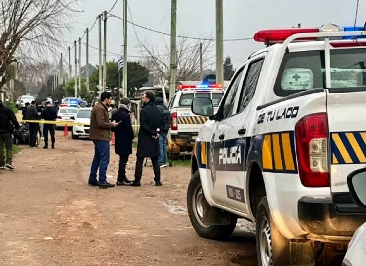 Patrullero policial con luces encendidas respondiendo a un llamado de emergencia en una calle céntrica.
