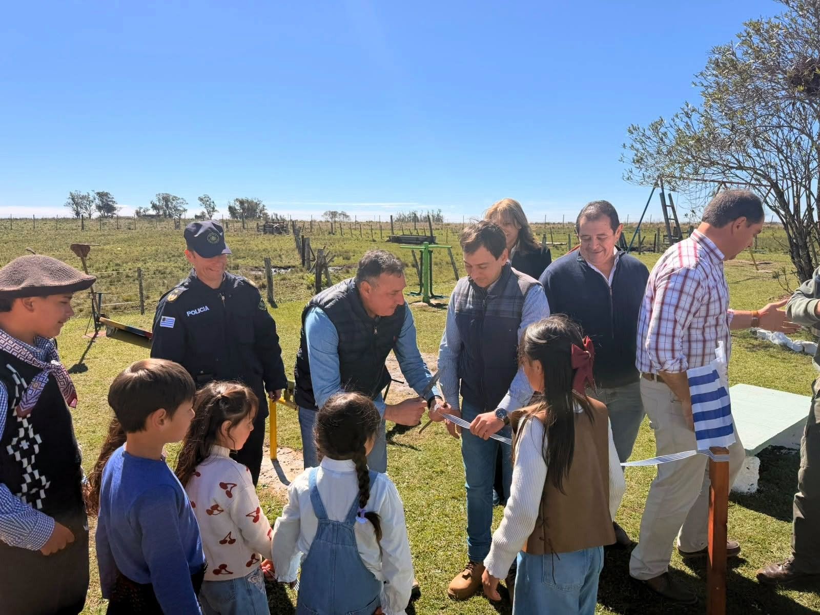 El intendente Carlos Albisu junto a los alumnos y docentes de la Escuela Rural N.º 84 inaugurando los nuevos juegos.