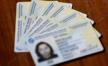 Cédula de identidad uruguaya apoyada junto a un celular moderno.