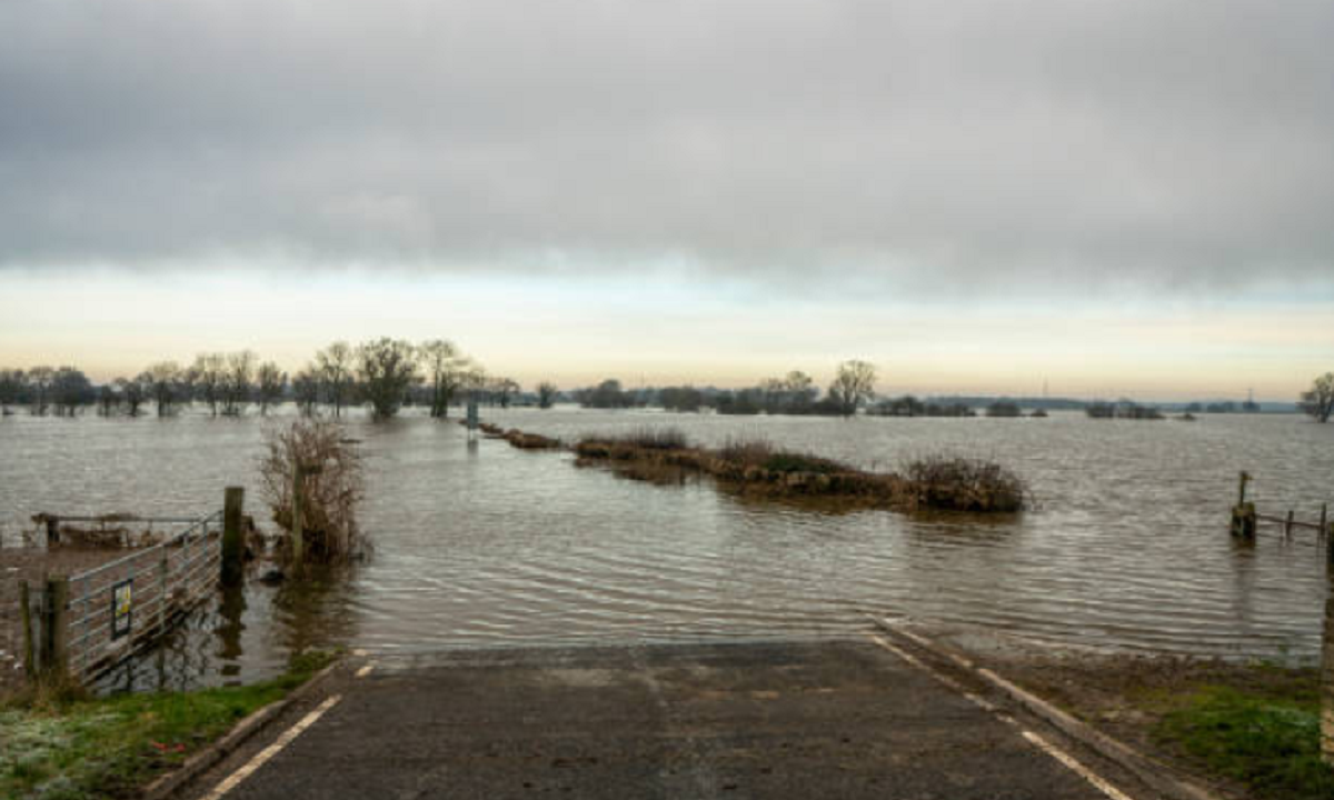 Camino rural de tierra anegado y destruido por lluvias intensas en el norte de Uruguay.