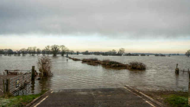 Camino rural de tierra anegado y destruido por lluvias intensas en el norte de Uruguay.