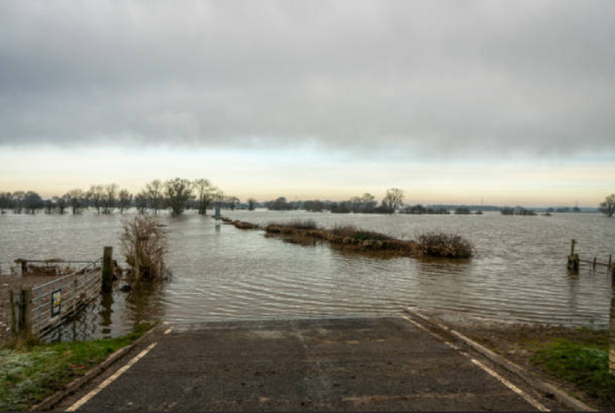Camino rural de tierra anegado y destruido por lluvias intensas en el norte de Uruguay.
