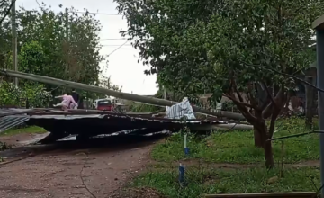 Techo de chapa de gran tamaño tirado en medio de una calle de tierra tras un fuerte temporal en Salto.
